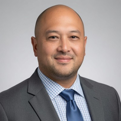 Mike Hamanaka in a gray suit and blue tie
